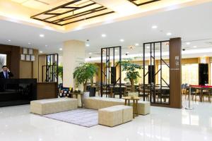 a lobby of a hotel with tables and chairs at Black Sands Hotel Jeju in Jeju