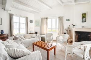 a living room with white furniture and a fireplace at Maison vue mer et marais salants in Loix