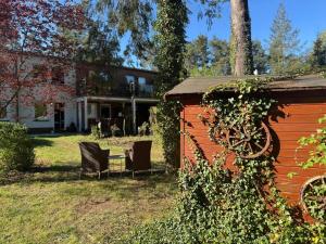 a house with two chairs and a table in the yard at FamilienNest XXL - direkt am See in Lychen
