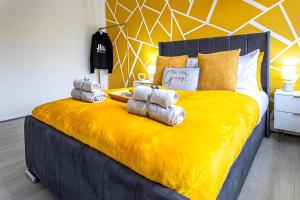 Long LawfordにあるDen Duplexのベッドルーム1室(大きな黄色のベッド1台、タオル付)