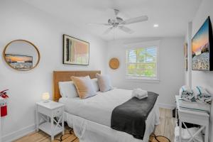 a white bedroom with a bed and a ceiling fan at Villa #2 Shrimp in Holmes Beach