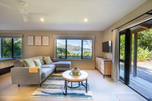 ein Wohnzimmer mit Sofa und Tisch in der Unterkunft Laneside - Akaroa Holiday Cottage in Akaroa