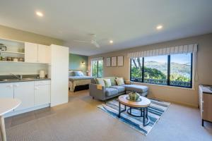 eine Küche und ein Wohnzimmer mit einer Couch und einem Tisch in der Unterkunft Laneside - Akaroa Holiday Cottage in Akaroa