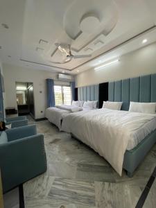 une grande chambre avec deux lits et un canapé dans l'établissement Aban Suites, à Dargai