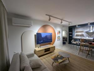 a living room with a couch and a flat screen tv at Solea Suites in Chernomorets