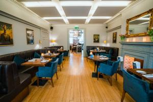 a restaurant with wooden tables and blue chairs at Purchases Restaurant & Accommodation in Chichester