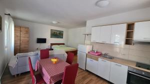 a kitchen with a table and a room with a bed at Apartments Ivanovski in Rab