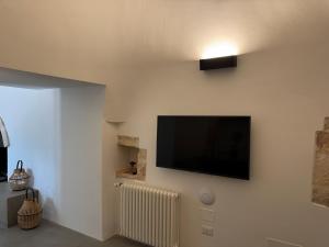 a living room with a flat screen tv on a wall at Trulli Mansueto in Noci
