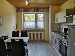a kitchen with a table and chairs and a window at Ferienwohnung am Schloßpark in Melsungen