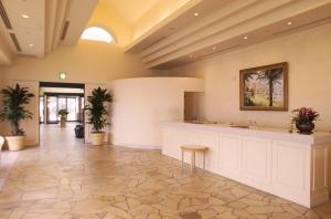 a lobby with a counter and potted plants at Yumihari-no-Oka Hotel in Sasebo