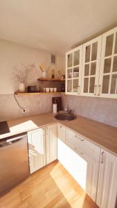 a kitchen with white cabinets and a sink at Korter vanalinna lähistel in Haapsalu +6 photos