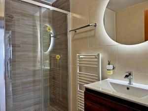 W łazience znajduje się prysznic, umywalka i lustro. w obiekcie Apartamento Esencia - Ole Solutions w mieście Arcos de la Frontera