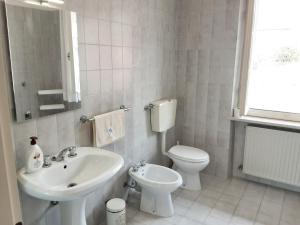 a white bathroom with a sink and a toilet at Affittacamere Casa Bliss in Venzone