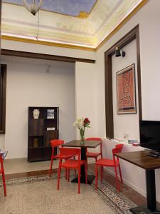 a dining room with a table and red chairs at Soste Normanne in Palermo