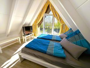 Dos camas en una habitación con una gran ventana. en Bulgenshuus Bensersiel, en Esens