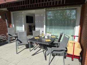 Una mesa y sillas negras en un patio. en Bulgenshuus Bensersiel, en Esens
