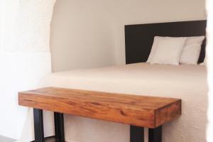 a bedroom with a bed with a wooden table at Trulli Mansueto in Noci +36 photos