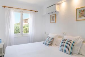 a white bedroom with a white bed and a window at Mar Hotels Alcanada in Port d'Alcudia
