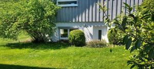 a house with a white door in a yard at Apartment Rietheim in Rietheim-Weilheim
