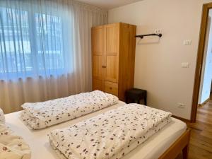 a bedroom with two beds and a dresser at Ferienwohnungen Preiss in Schenna