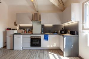 a large kitchen with white cabinets and appliances at Appartement Lumineux refait à Neuf in Sanary-sur-Mer +9 photos