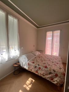 a bedroom with a bed with a floral bedspread and two windows at A Casa Di Lu Na 3 in Bologna