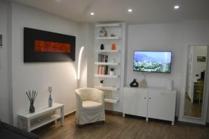 a living room with a chair and a tv on a wall at al larghetto n5 in Salerno
