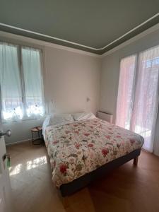 a bedroom with a bed with a floral bedspread and windows at A Casa Di Lu Na 3 in Bologna