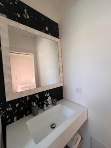 a bathroom with a white sink and a mirror at A Casa Di Lu Na 3 in Bologna