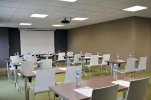 a conference room with tables and chairs and a whiteboard at Sure Hotel By Best Western Guerande in Guérande