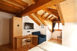 a bedroom with a bed and a desk in a room at Affittacamere Alle Trote in Sùtrio