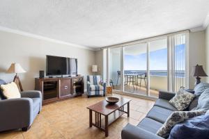 a living room with a couch and a tv and a table at Perdido Sun 1010 in Perdido Key