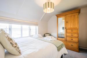 een slaapkamer met een wit bed en een groot raam bij Stable Cottage, Friston in Friston