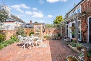 een patio met een tafel en stoelen in een tuin bij Stable Cottage, Friston in Friston