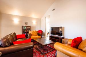 a living room with leather furniture and a flat screen tv at Charm on Chestnut in Paso Robles