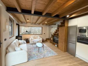 a living room with a white couch and a kitchen at La era de Somaniezo in Luriezo