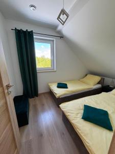 two beds in a room with a window at Apartamenty Gajewscy in Lipnica Górna