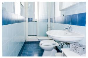 a blue and white bathroom with a toilet and a sink at Ostia Holiday Circe in Lido di Ostia