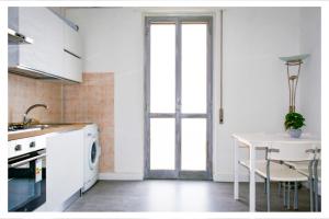 a kitchen with a white table and a window at Ostia Holiday Circe in Lido di Ostia