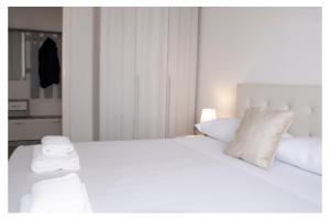 a white bed with two towels on top of it at Ostia Holiday Circe in Lido di Ostia