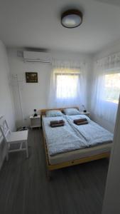 a bedroom with a large bed with two pillows on it at Budatava Vendégház in Balatonalmádi