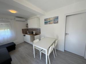 a small kitchen with a white table and chairs at Budatava Vendégház in Balatonalmádi