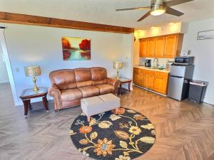 a living room with a leather couch and a kitchen at Marina Access Lake View Golf Swimming Fishing with All Holiday Island Amenities Accessible in Holiday Island