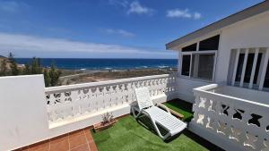 a balcony with a chair and a view of the ocean at Villa Vargas Paraiso in Carrizal