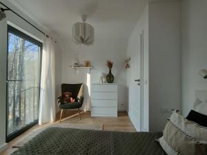 a bedroom with a chair with a teddy bear in it at Domki Czarny Bocian in Białogóra