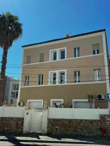 a building with a fence and a palm tree at Residence Enzo Paradise in La Seyne-sur-Mer