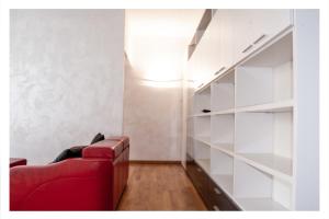 a living room with a red couch and shelves at Ostia Holiday La Marina in Lido di Ostia