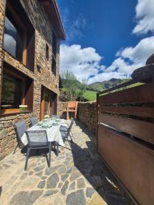 a patio with a table and chairs and a building at La era de Somaniezo in Luriezo