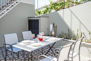 CanhasCocoon House的庭院里配有带椅子和酒杯的白色桌子