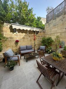 a patio with tables and chairs and a brick wall at Dahlia apartment - Paola Modern Townhouse in Paola